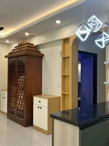 A similar view to ID 108, capturing the beautiful pooja unit, modern kitchen counter, and statement lighting that define this open-concept living space.