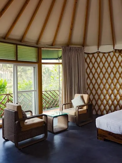 The spacious and airy interior of our riverside cottages, with large windows offering panoramic views of the surrounding greenery.