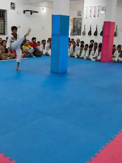 Two students demonstrate a kicking combination.
