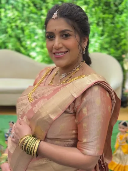 A beautiful shot of the mom-to-be cradling her baby bump. The saree is draped to flatter her figure while providing maximum comfort.