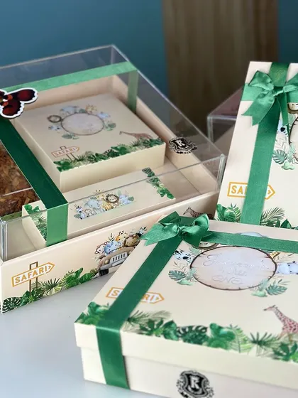 The complete jungle themed hamper set, showing the main gift box alongside smaller favor boxes, all tied with a matching green ribbon.