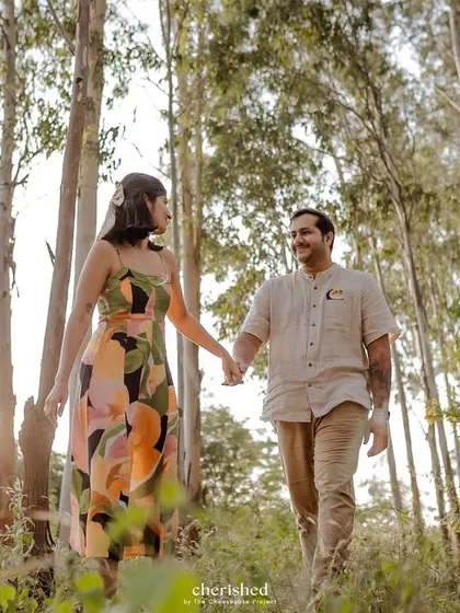 A couple walking hand-in-hand through a sunlit forest. Perfect for an engagement or pre-wedding session.