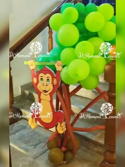 A creative use of balloons and a monkey cutout to decorate a staircase railing for a jungle party.