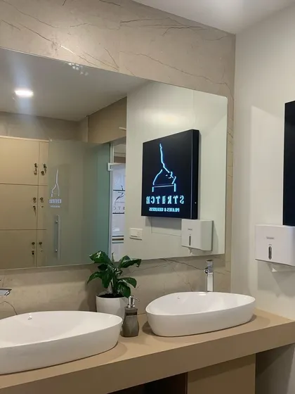 A look at our clean and modern wellness facilities, including lockers and washroom area, featuring our brand logo.