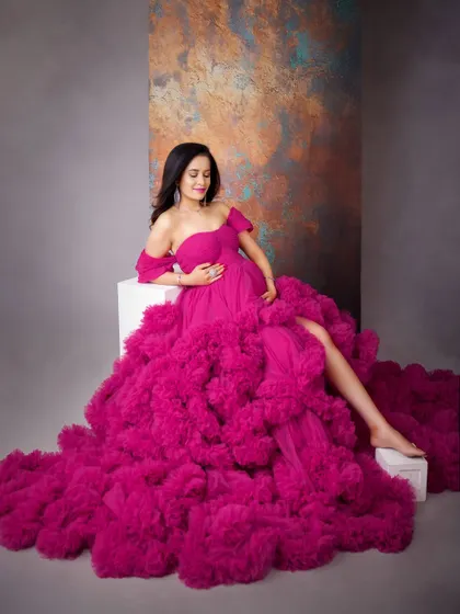 A moment of quiet reflection in a magnificent pink gown. The soft lighting and gentle pose highlight the beauty and serenity of pregnancy.
