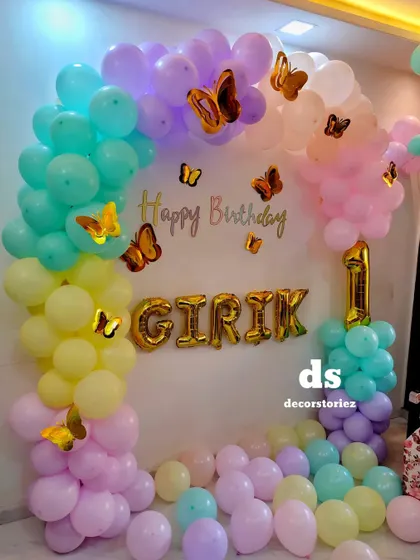 A close-up of the butterfly balloon arch with the baby's name in large foil letters. This personalized touch makes the celebration feel extra special.
