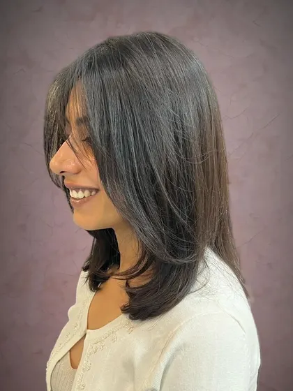 A side view of the long bob with face-framing curtain bangs.