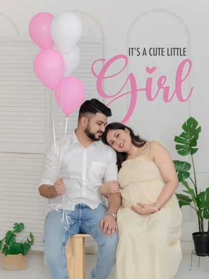 A classic and joyful gender reveal portrait with pink balloons celebrating the news that "It's a cute little Girl."