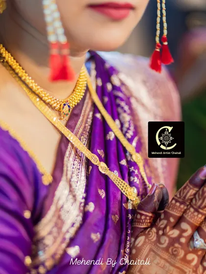 A detailed shot focusing on the bridal jewelry and the mehendi stain on her hands. Every element comes together to create a timeless bridal look.