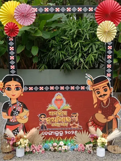 A beautiful photo booth for a traditional Nuakhai Juhar celebration. The frame features cultural illustrations and is decorated with paper fans and flowers, blending tradition with fun.