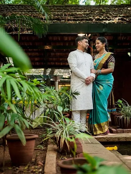 A full-length portrait of a couple in a beautiful garden setting, showcasing their connection and the lovely surroundings.