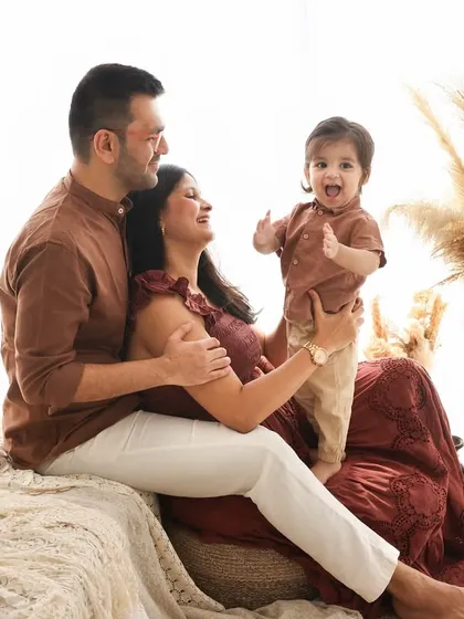 A family portrait bursting with energy and laughter. The little one's excited expression is the centerpiece of this joyful moment captured in our studio.