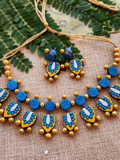 The same two-layer leaf charm necklace in a blue and yellow combination.