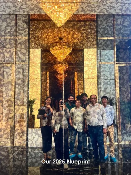 A photo of our team on a site visit, standing before a grand, reflective wall. This image captures the collaborative spirit and hands-on approach we bring to every project.
