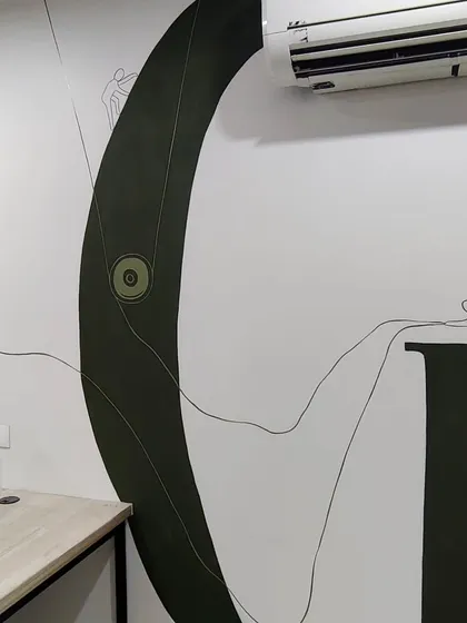 A close-up of the letter 'G' in the office mural, showing the detailed line art that adds a narrative layer to the bold typography.
