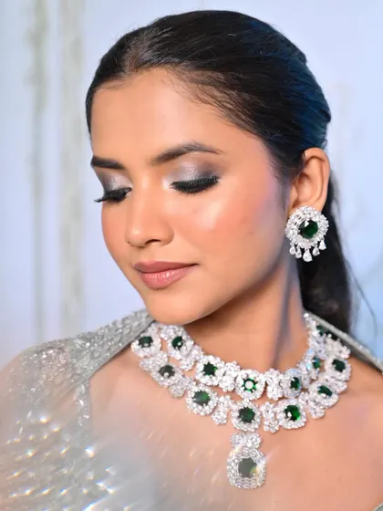 A close-up of the silver smokey eye with a pop of emerald green from the jewelry, a great example of coordinating makeup with accessories.