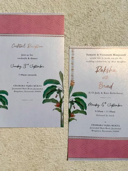 The full view of the metallic board invitation suite. The combination of the pink patterned border, banana leaf motifs, and gold typography creates a look that is both contemporary and culturally rooted.