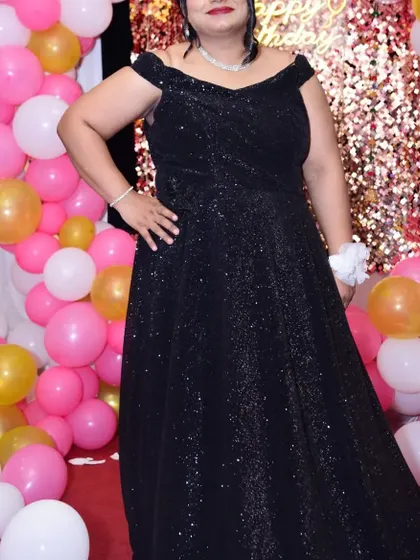 Celebrate your special events in my designed outfits without spending a fortune. This black off-shoulder sequin gown is a classic choice for any party, available to rent or buy.