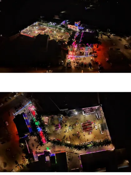 A high-altitude aerial view of a large, brightly lit event venue at night. This shot is ideal for showcasing the full scale and layout of a property.