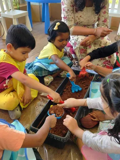 Little gardeners getting their hands dirty. This photo from our gardening workshop shows children learning about nature through direct, hands-on experience with soil and plants.