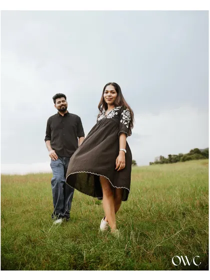 A carefree moment in a green field, with the bride-to-be's dress catching the wind, creating a sense of movement and joy.