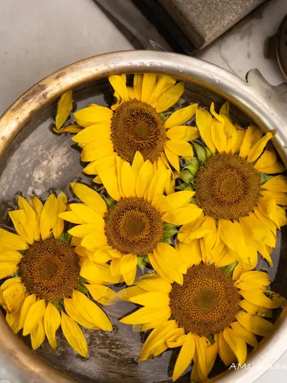 A bowl of floating sunflowers, a simple yet beautiful way to incorporate the theme of sunshine and happiness into the decor.