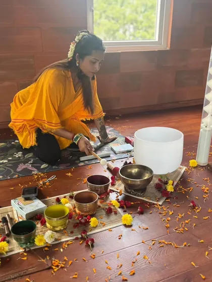 Preparing my setup of chakra tuned singing bowls and a large crystal bowl. The space is decorated with marigold and rose petals to create a sacred and visually beautiful environment for healing.