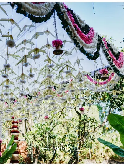 A ceiling of woven palm leaves and flowers, with hanging temple bells, creates a stunning and unique look.