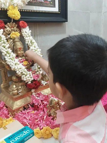 A child offers flowers to an idol of Goddess Saraswati during our Vasant Panchami celebration. This act of reverence introduces children to cultural traditions.