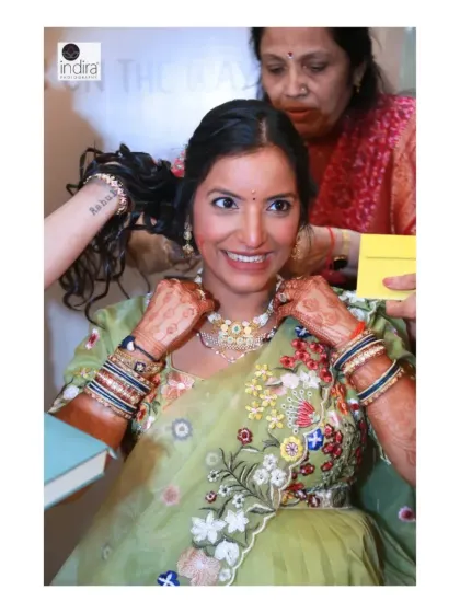 The mother-to-be getting ready, a candid shot of family helping her with her jewelry. These behind-the-scenes moments are part of the story.