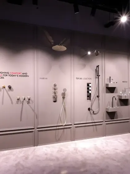 This section of the Fima showroom acts as a gallery wall for shower systems and fixtures. The products are mounted on a paneled grey wall with clear descriptions, allowing customers to easily compare different styles, from classic to modern.