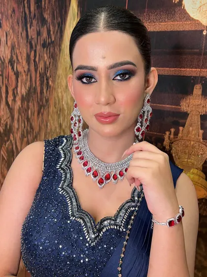 No paint, no plaster, just beautiful Indian skin. For this engagement bride, I created a bold blue smokey eye that complements her navy and red outfit, proving you don't need to hide your skin tone to look gorgeous.
