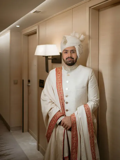 A full-length portrait of the groom in his wedding day attire, looking regal and ready for the ceremony.