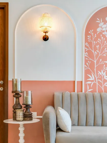 In this compact 3BHK, we used hand-painted mural arches instead of traditional panels to add depth and charm without making the space feel cramped. The soft pink and white floral design is both sweet and sophisticated.