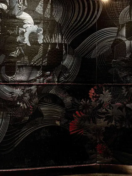 A close-up of the 'Gothilicious' textile, highlighting the rich textures and moody color palette. The piece is designed to be both sensual and sensorial.