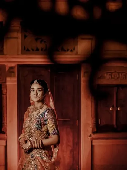 An artistic portrait of the bride in a palace-like setting, using shadows and warm light to create a moody and dramatic effect.