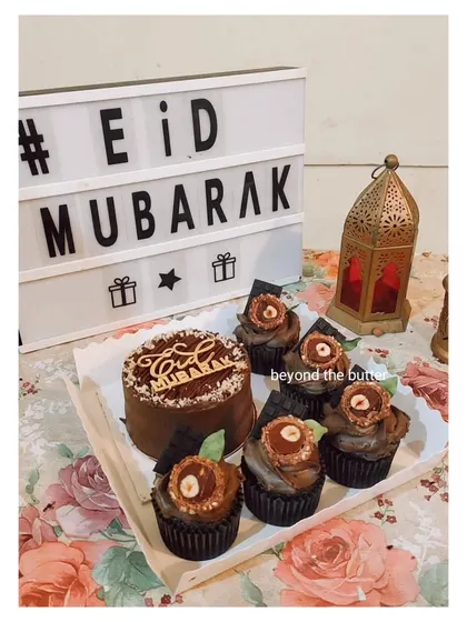 A chocolate-themed Eid bento box. This set includes a 4-inch chocolate cake with an "Eid Mubarak" topper and five matching chocolate cupcakes.