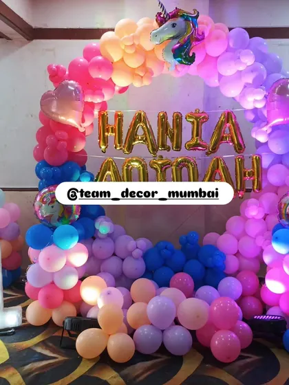 Another view of the vibrant unicorn balloon arch, showing the mix of pink, purple, orange, and blue balloons that create a magical rainbow effect.