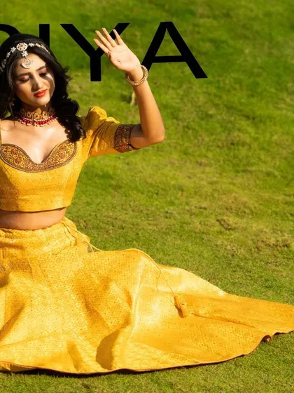 A creative, magazine-style shot of Priyadarshini SK in a vibrant yellow lehenga, set against a lush green lawn.
