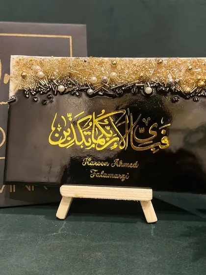 A personalized tabletop plaque with the Surah Ar-Rahman verse, shown with my studio's branding and packaging.