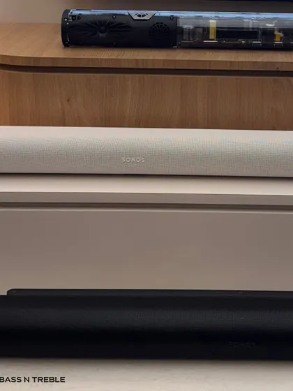 A close-up of the Sonos soundbars in black and white finishes. The fabric grille and minimalist design allow them to blend seamlessly below a television, while the technology inside delivers a surprisingly powerful audio experience.