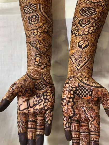 Full bridal henna with a mix of checkerboard (jaali) patterns, floral work, and personalized names.