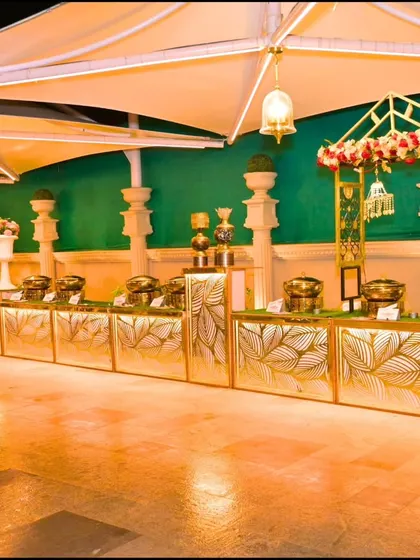 An impeccably styled buffet counter. The gold-leaf patterned counters under a tented roof added a touch of luxury to the dining experience, ensuring every aspect of the event felt special.
