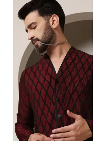 A detailed shot of the 'Maroon Ragalia' kurta, focusing on the texture of the fabric and the black pintuck detailing. This is a piece where the craftsmanship is meant to be seen up close.