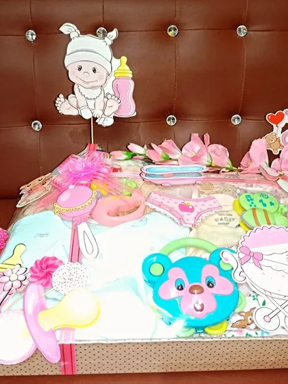 A beautiful tray hamper for a baby girl, decorated with lots of pink flowers and cute baby-themed cutouts.