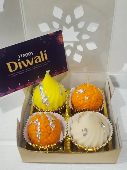 These are my sweet Mithai Candles, a truly unique gift for Diwali. This set includes candles shaped like a modak, motichoor ladoo, and peda, all beautifully packaged and ready to light up the festive season.