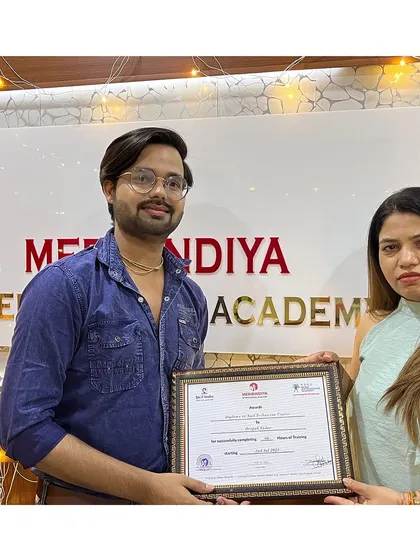 A male graduate proudly receives his certificate, ready to excel in the world of professional hairstyling and makeup.
