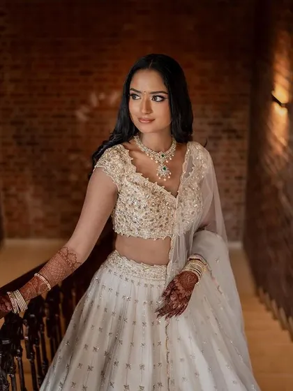 A stunning bride in a white lehenga, exuding grace and elegance. We use creative framing and lighting to capture a variety of beautiful portraits.