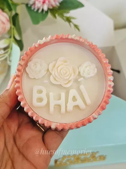A close-up of my custom Rakshabandhan candle, personalized with 'BHAI'. These are made with soy wax in a hand-poured eco-resin jar, available in 15 vessel shapes and 10 fragrances to match your festive decor.