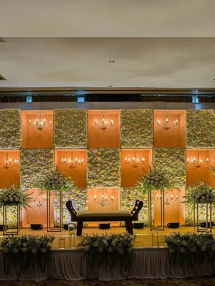This engagement and reception stage combines floral panels with inset chandeliers for a warm, classic look. The design provides beautiful, soft lighting and a sense of timeless elegance.
